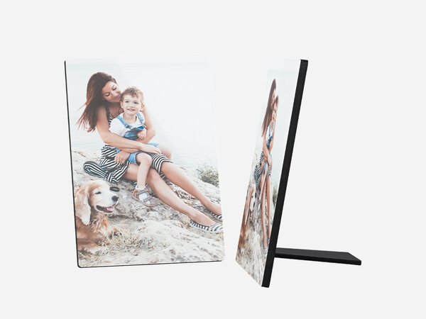 Ein Fotoaufsteller zeigt ein schönes Bild von einer jungen Frau, einem kleinen Kind und einem goldenen Retriever-Hund. Die Frau hat lange, braune Haare und trägt ein gemustertes Top und einen Rock. 